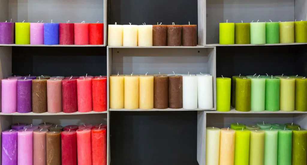 rows of different colored candles on display in a store.