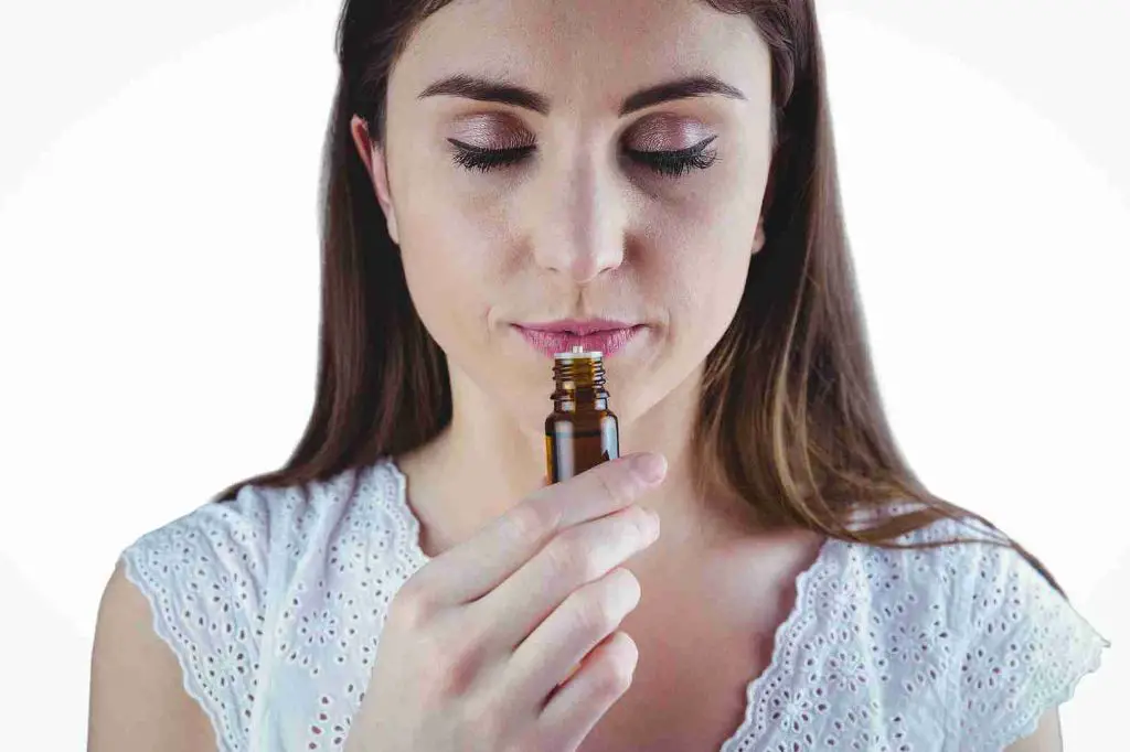 someone sniffing an essential oil bottle to evaluate the scent