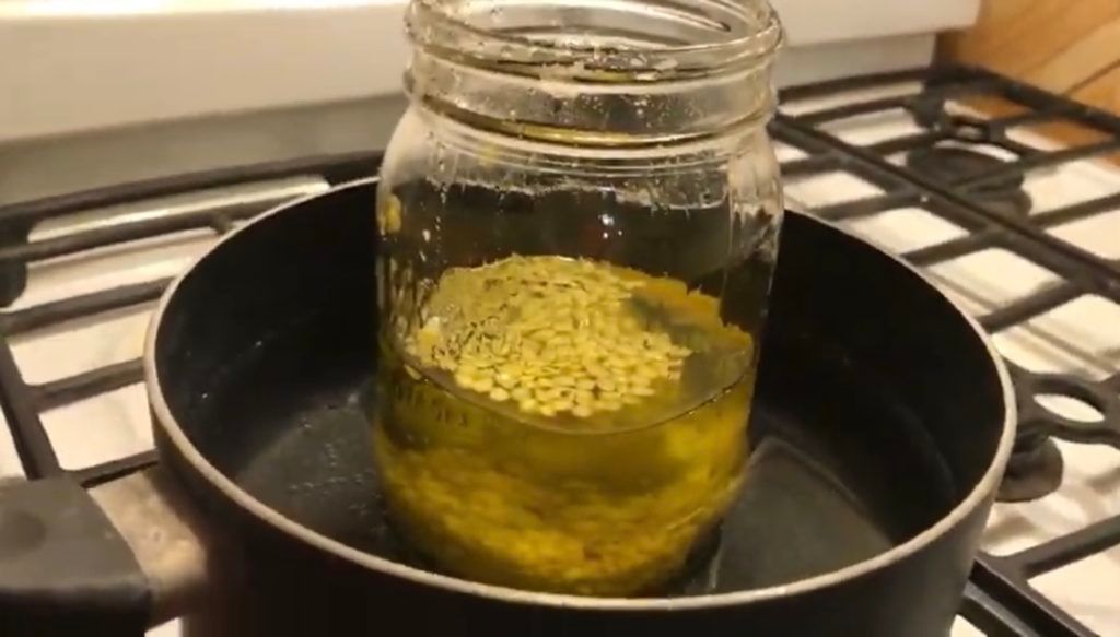 someone using a double boiler to melt wax