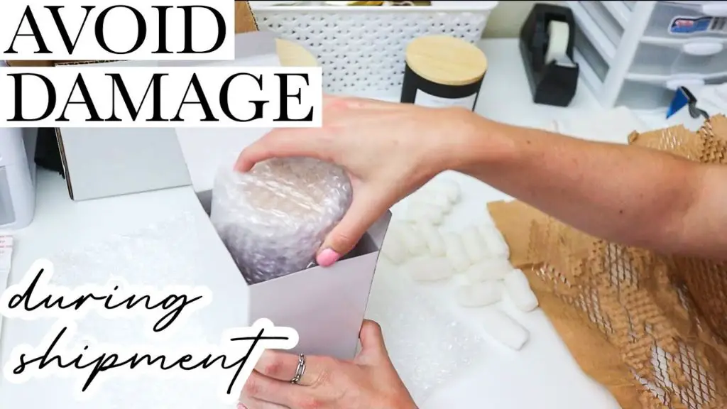 someone wrapping a candle in bubble wrap before placing in box