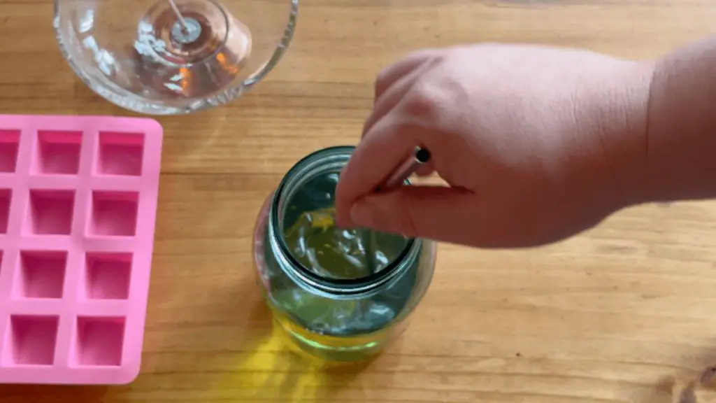 soy wax being poured into a glass jar mold