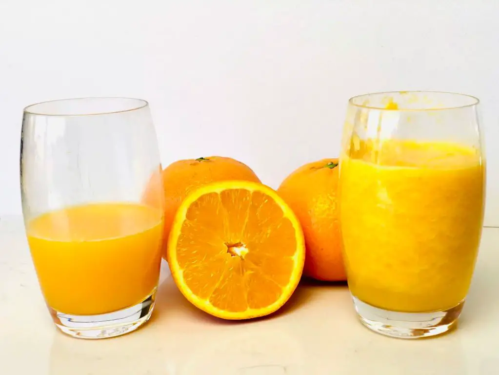 sweet oranges being juiced into orange juice
