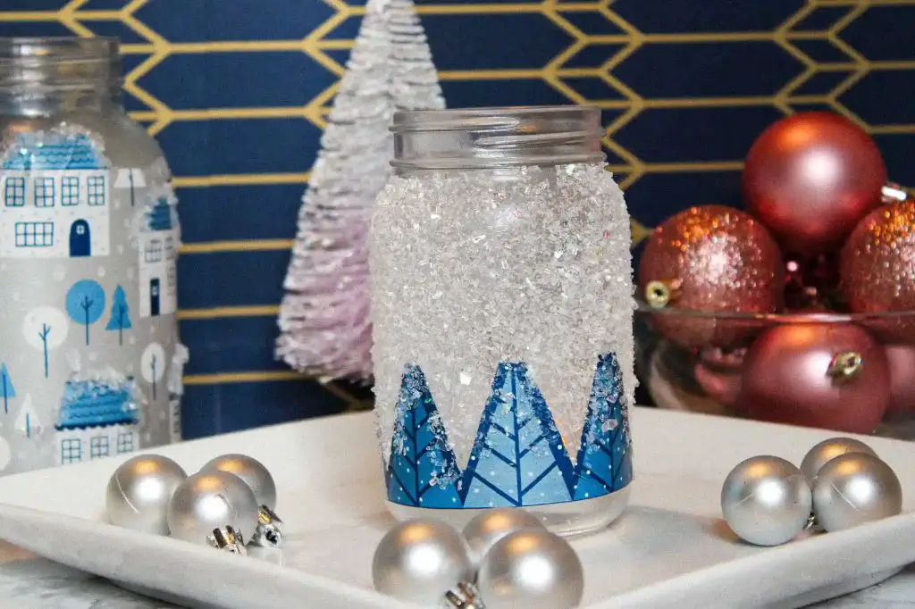 the winter candle comes in a frosted blue glass jar decorated with a snowflake pattern.