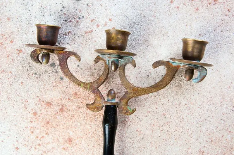 washing antique brass candlesticks with a mild soap solution using a soft cloth.