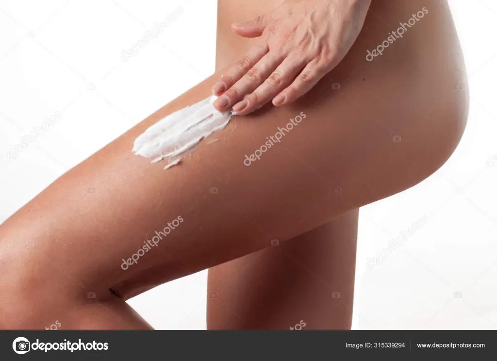 woman applying anti-cellulite cream on her thighs