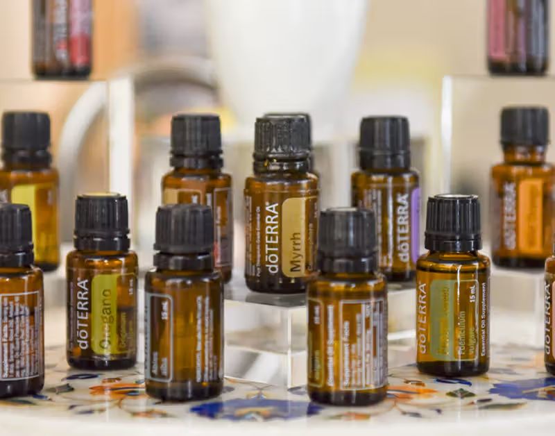 woman cupping her hands around a diffuser emitting myrrh essential oil