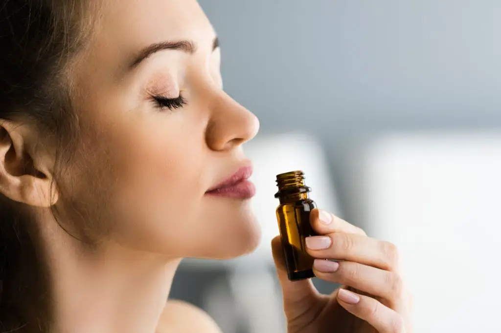 woman inhaling litsea essential oil with a serene expression