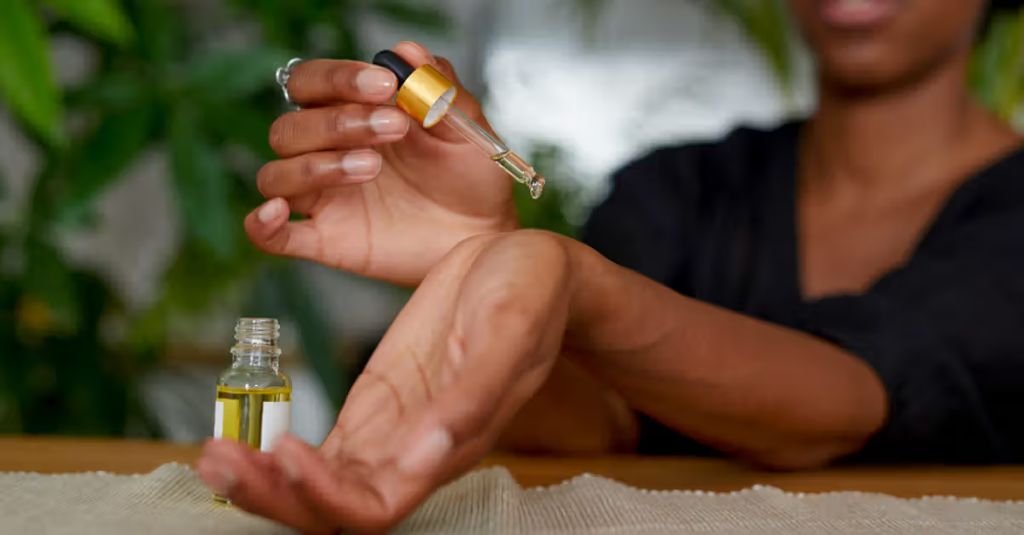 woman spraying clove oil insect repellent onto her arm