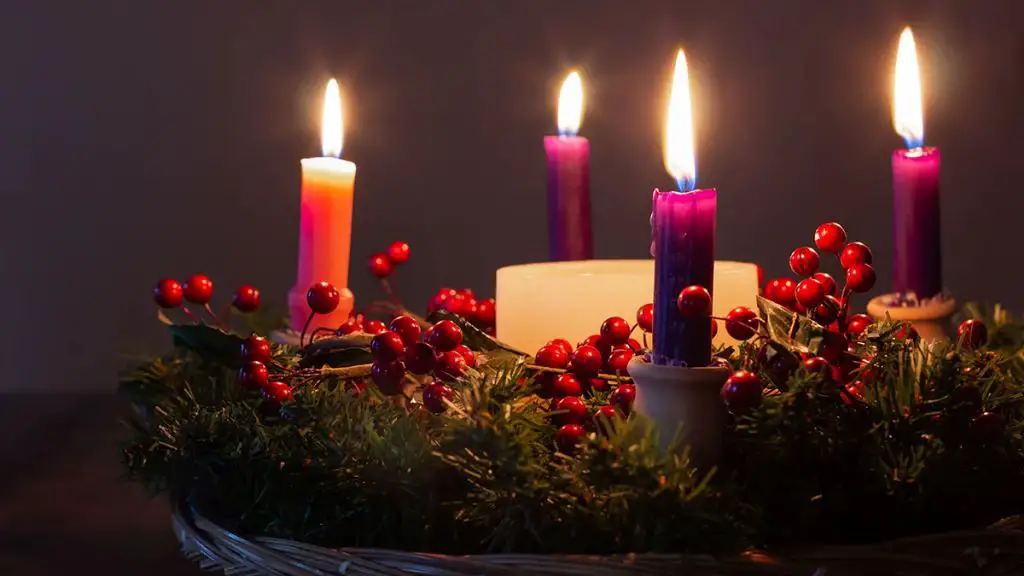 an advent wreath with candles lit to mark the weeks leading up to christmas.