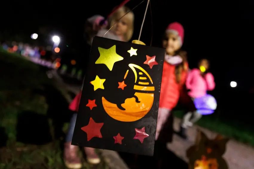 children carrying paper lanterns during a st. martin's day parade