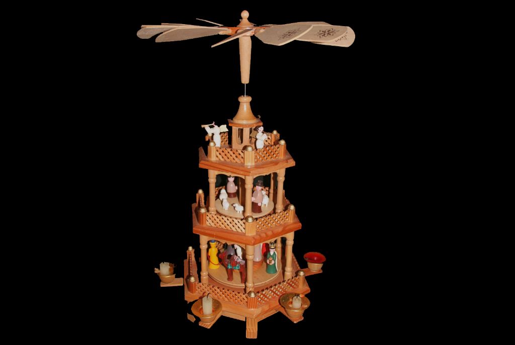 inside view of a christmas pyramid showing the central metal rod and spinning levels that rotate when heated by a candle.