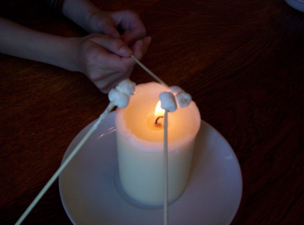 marshmallow being toasted over candle flame