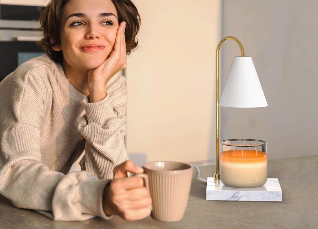 woman using candle warmer on table
