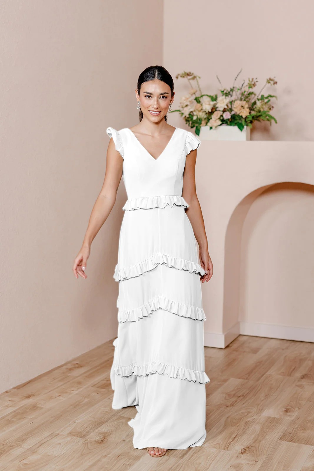 If you’re into simple yet lively designs, consider a dress with tiers or ruffles, which add subtle youthfulness to any gown. The carefree silhouette and breezy fabric would suit a mountainside ceremony in the summer.