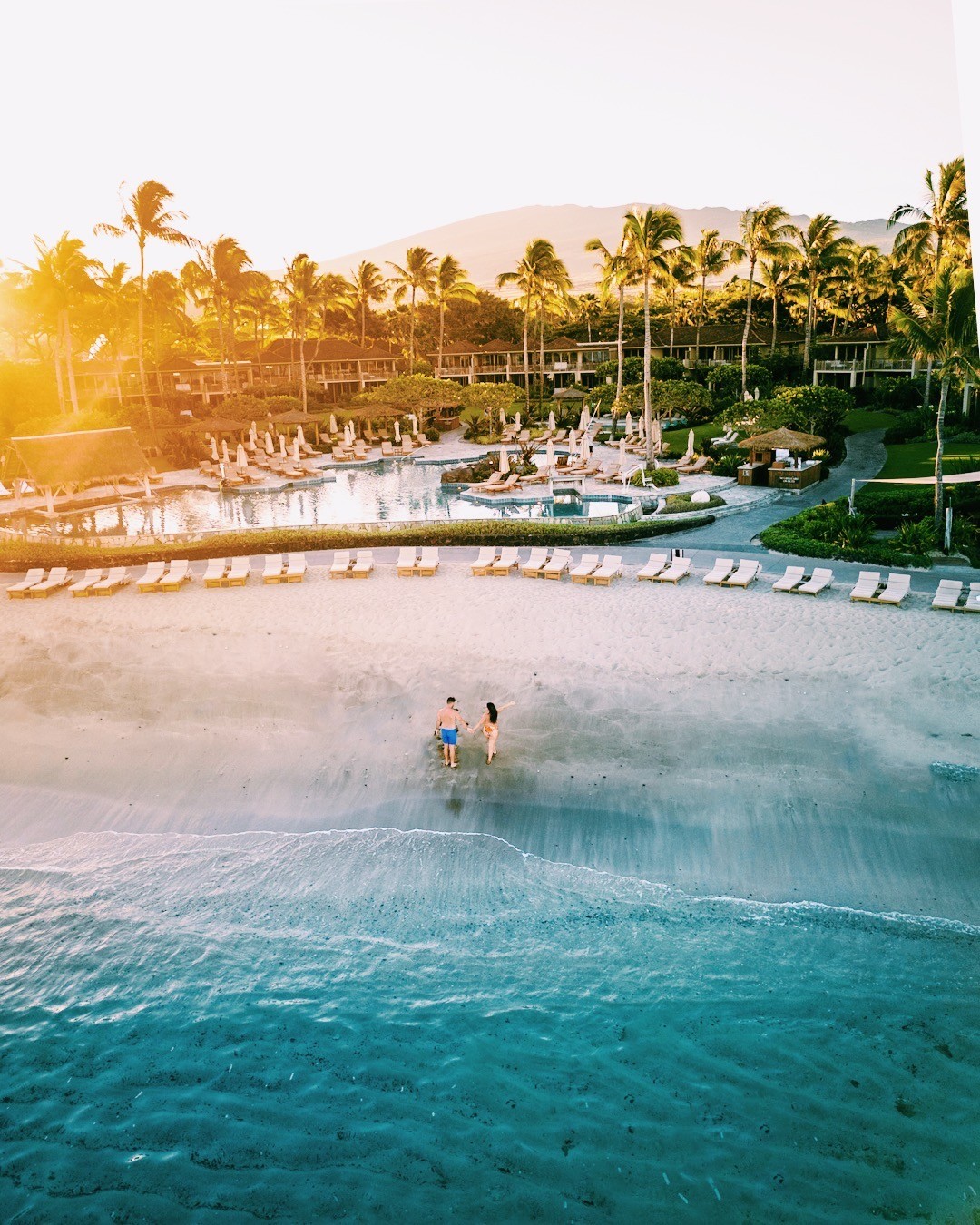 What are the luxurious accommodations, food options, and activities available for wedding parties at the Four Seasons Resort Hualalai?