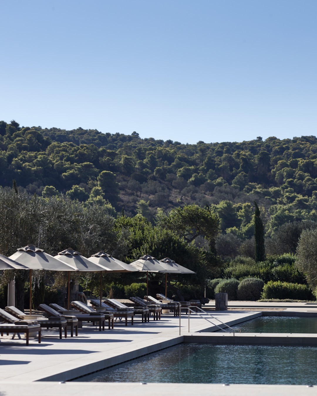 What are the luxurious accommodations, food options, and activities available for wedding parties at Amanzoe, Porto Heli?